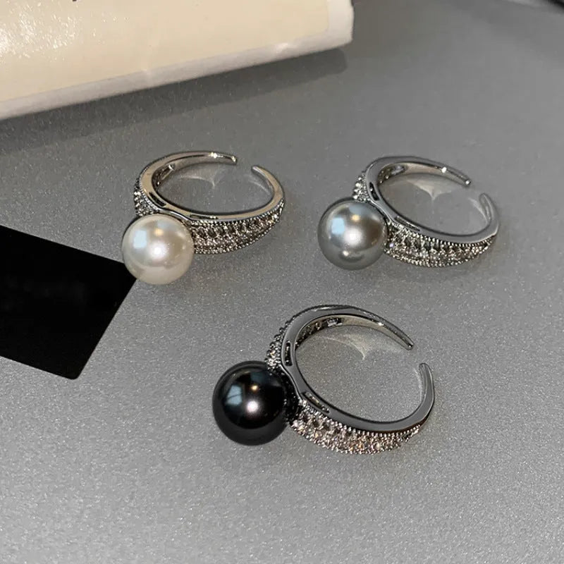 Adjustable open copper ring with geometric shape and black pearl detail on index finger