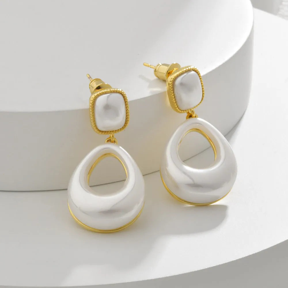 Gold-coloured water drop shaped mabe pearl earrings with imitation pearl components