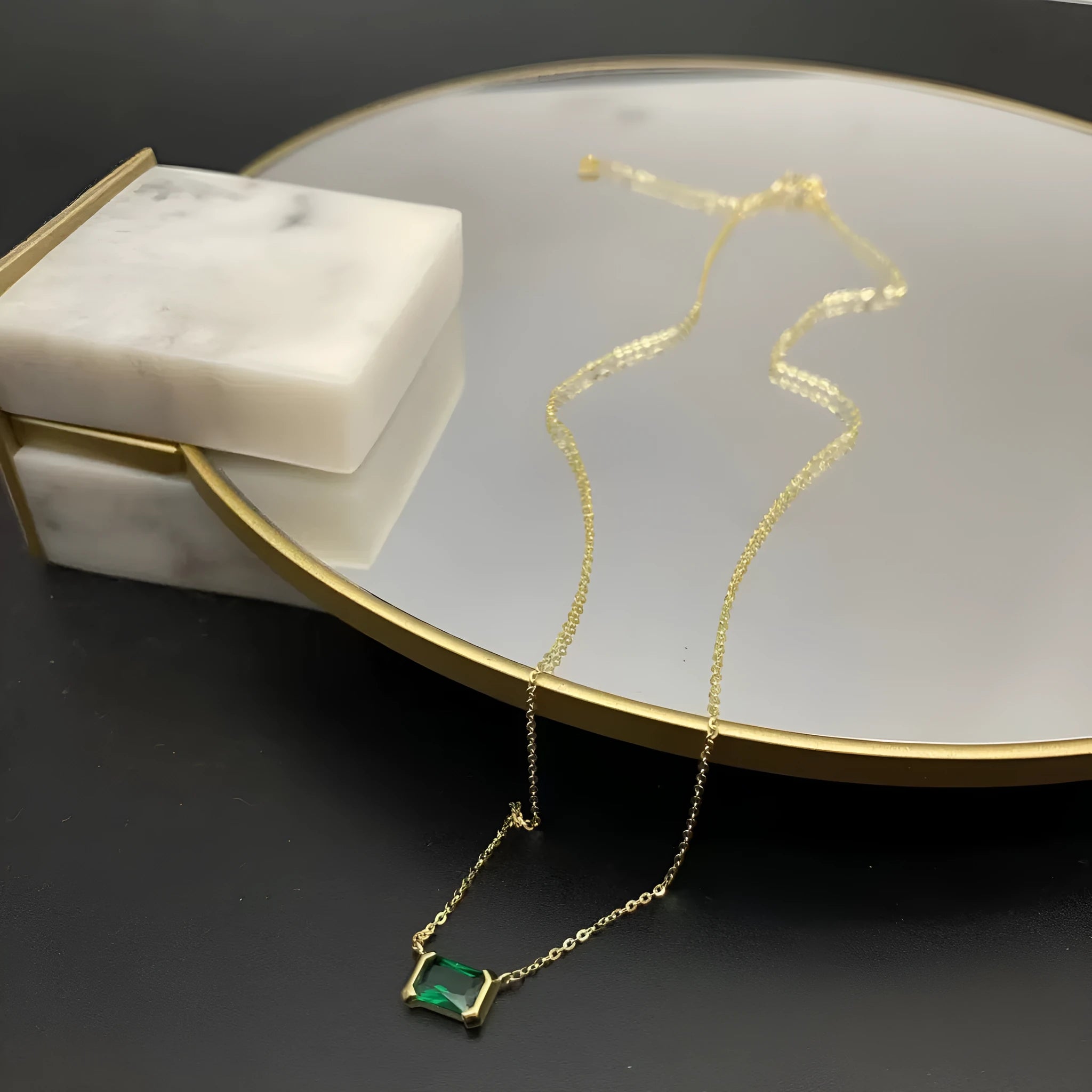 Gold geometric quadrilateral pendant necklace with inlaid cubic zirconia stones on a chain.