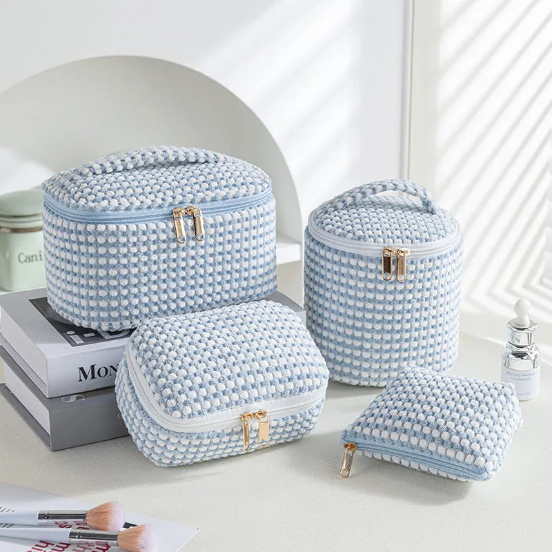 Four cube style makeup bags in different colour patterns including pink, khaki, and dotted designs