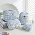 Four cube style makeup bags in different colour patterns including pink, khaki, and dotted designs