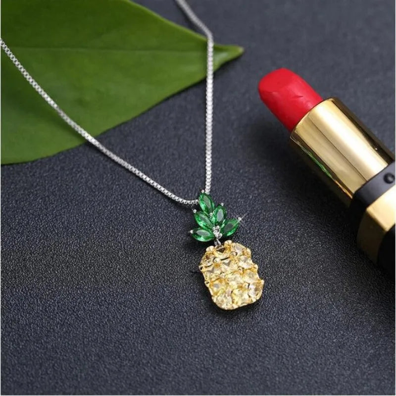 Silver geometric pineapple pendant necklace with diamond details on a model.