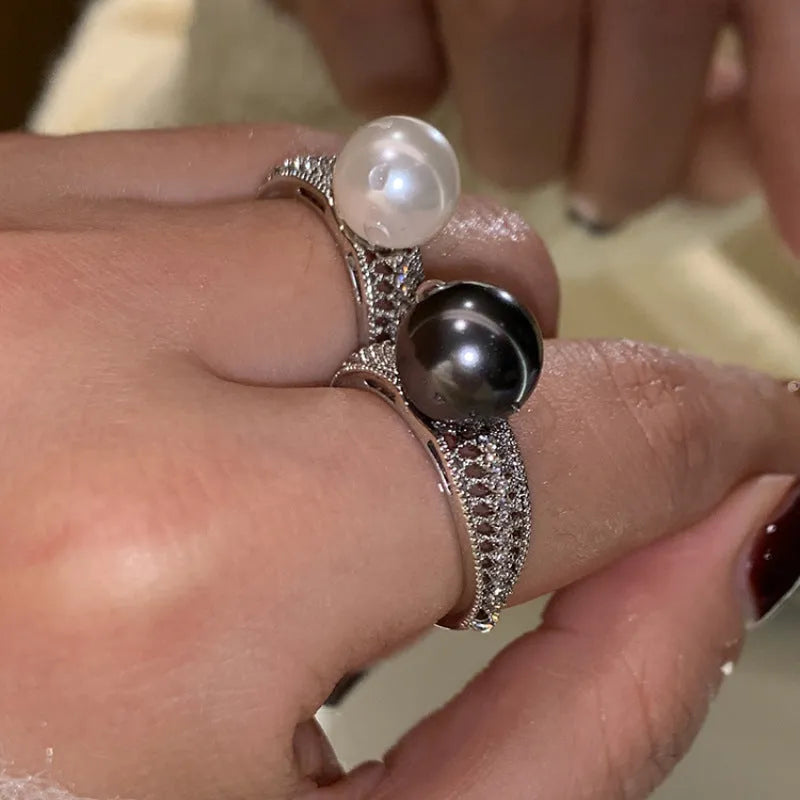 Adjustable open copper ring with geometric shape and black pearl detail on index finger