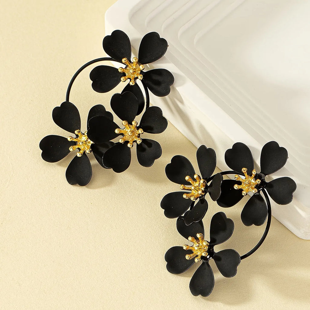 Retro flower-shaped iron earrings for women in black and white colour options.