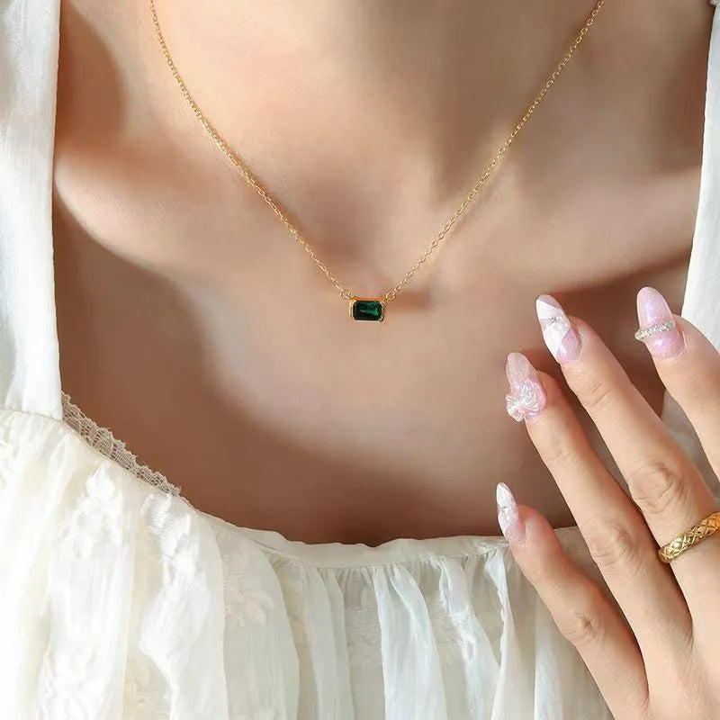 Gold geometric quadrilateral pendant necklace with inlaid cubic zirconia stones on a chain.