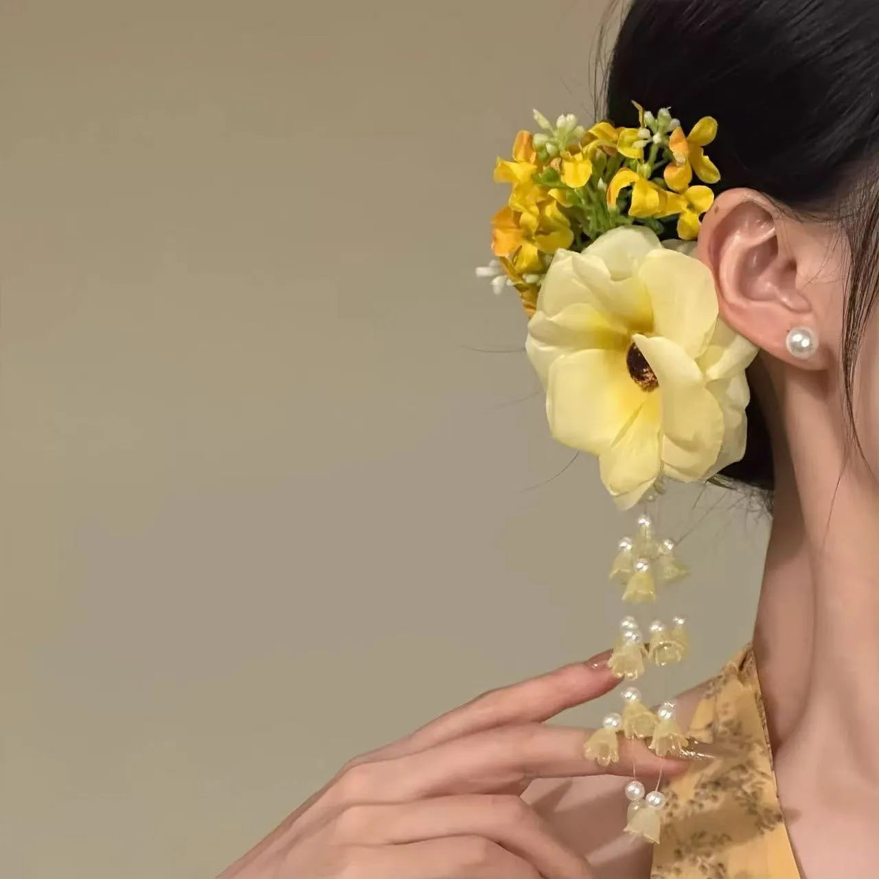 Women's floral tassel side clip hair accessory in purple or yellow on white background.