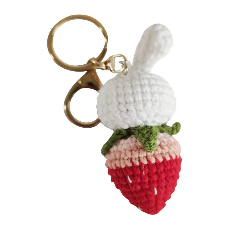 Hand-woven white wire pendant charm with a cartoon rabbit and strawberry design on a key.