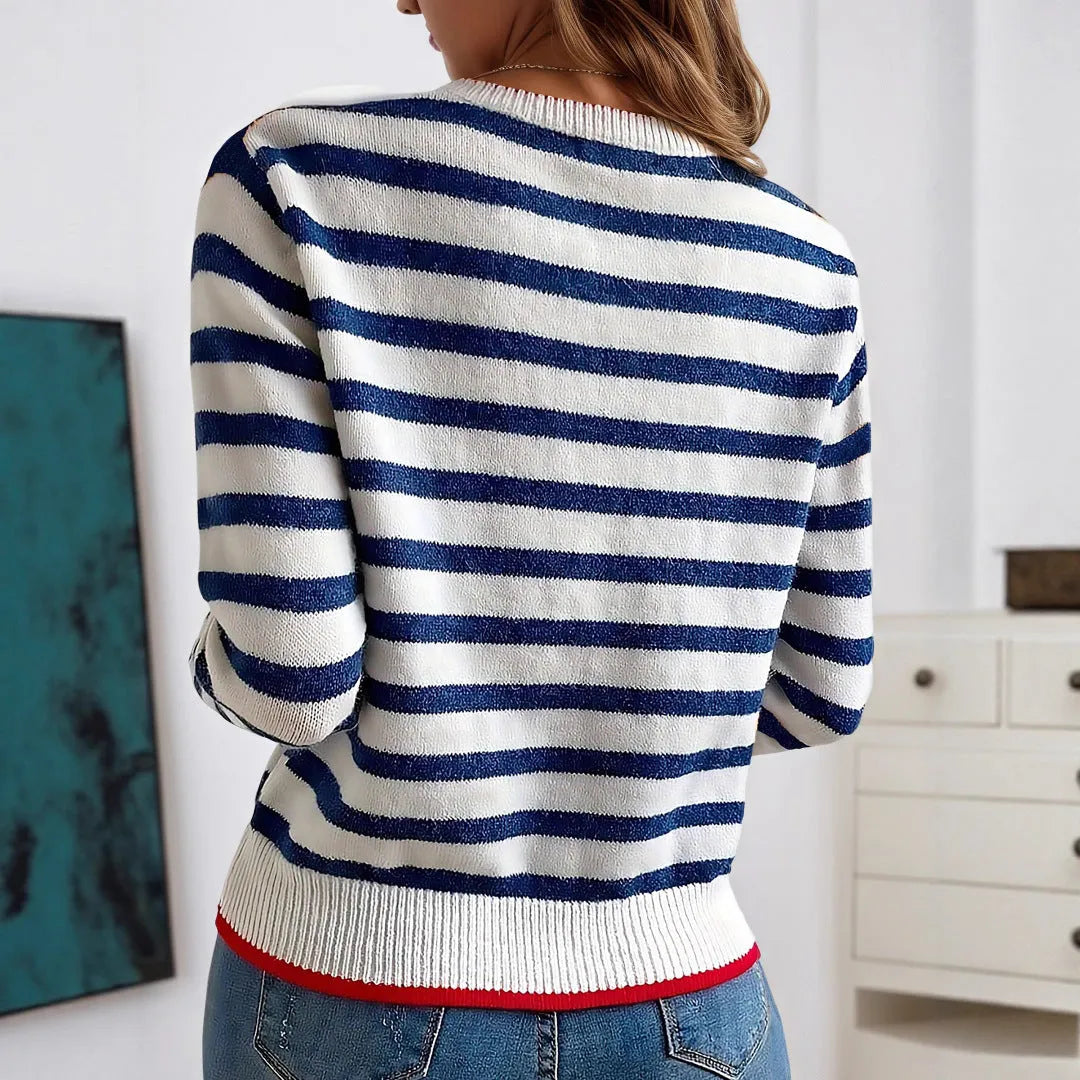 Sapphire blue striped loose fit pullover sweater with round neck and long sleeves on a hanger.