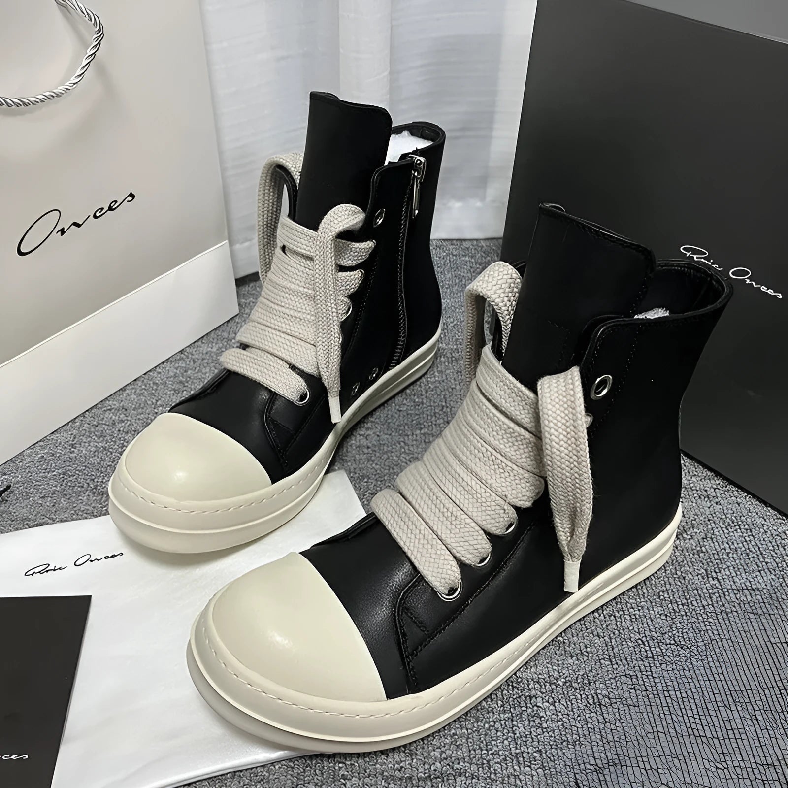 Black high-top leather sneaker boots with a side zipper and a thick rubber platform sole.