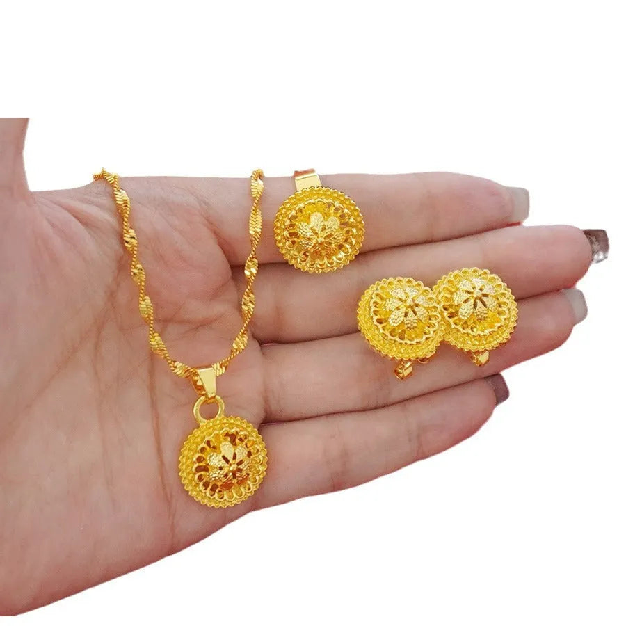 Gold-plated women's three-piece jewelry set showing necklace with floral pendant, matching earrings, and ring