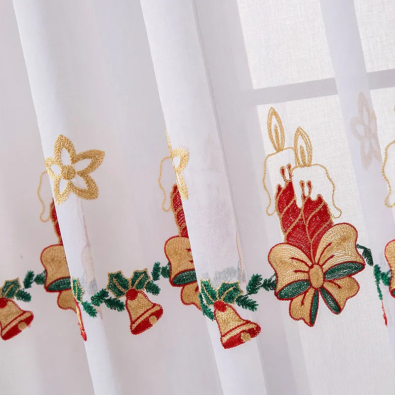 Pair of white polyester Christmas curtains with embroidered red snowflake design hung on a window