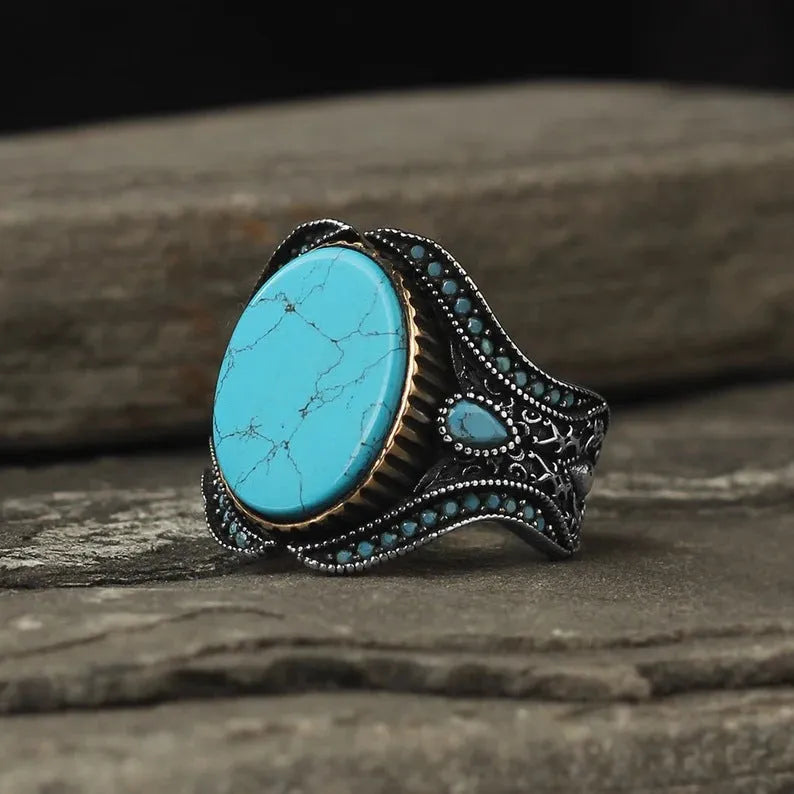Men's round turquoise alloy ring with antique silver finish shown on finger