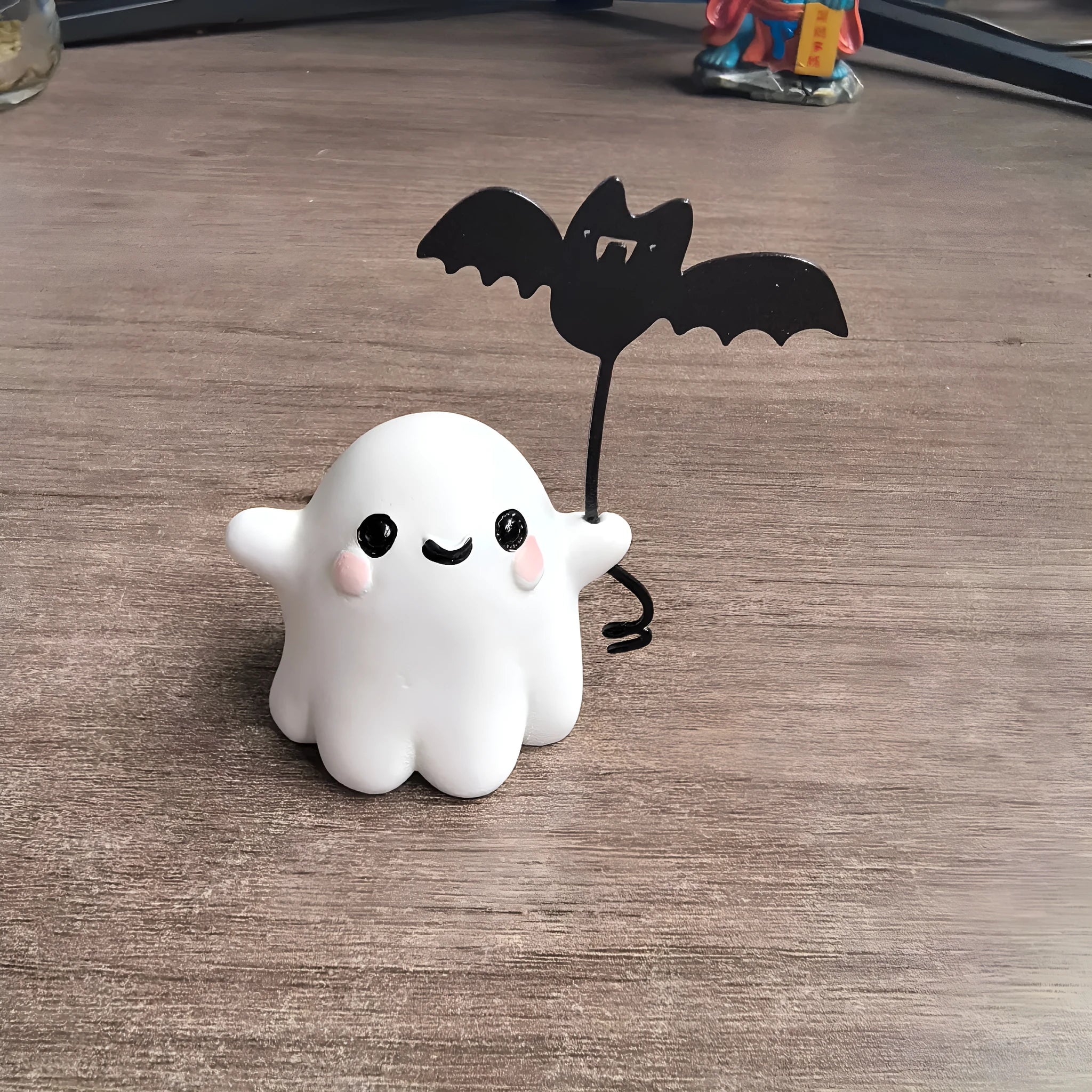 Small resin statue of a ghost walking a dog, a Halloween decoration.