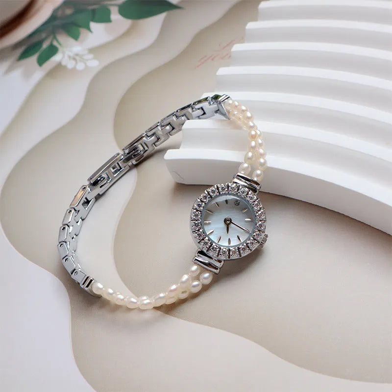 Light gold women's bracelet watch with freshwater pearls, round dial, and stainless steel strap