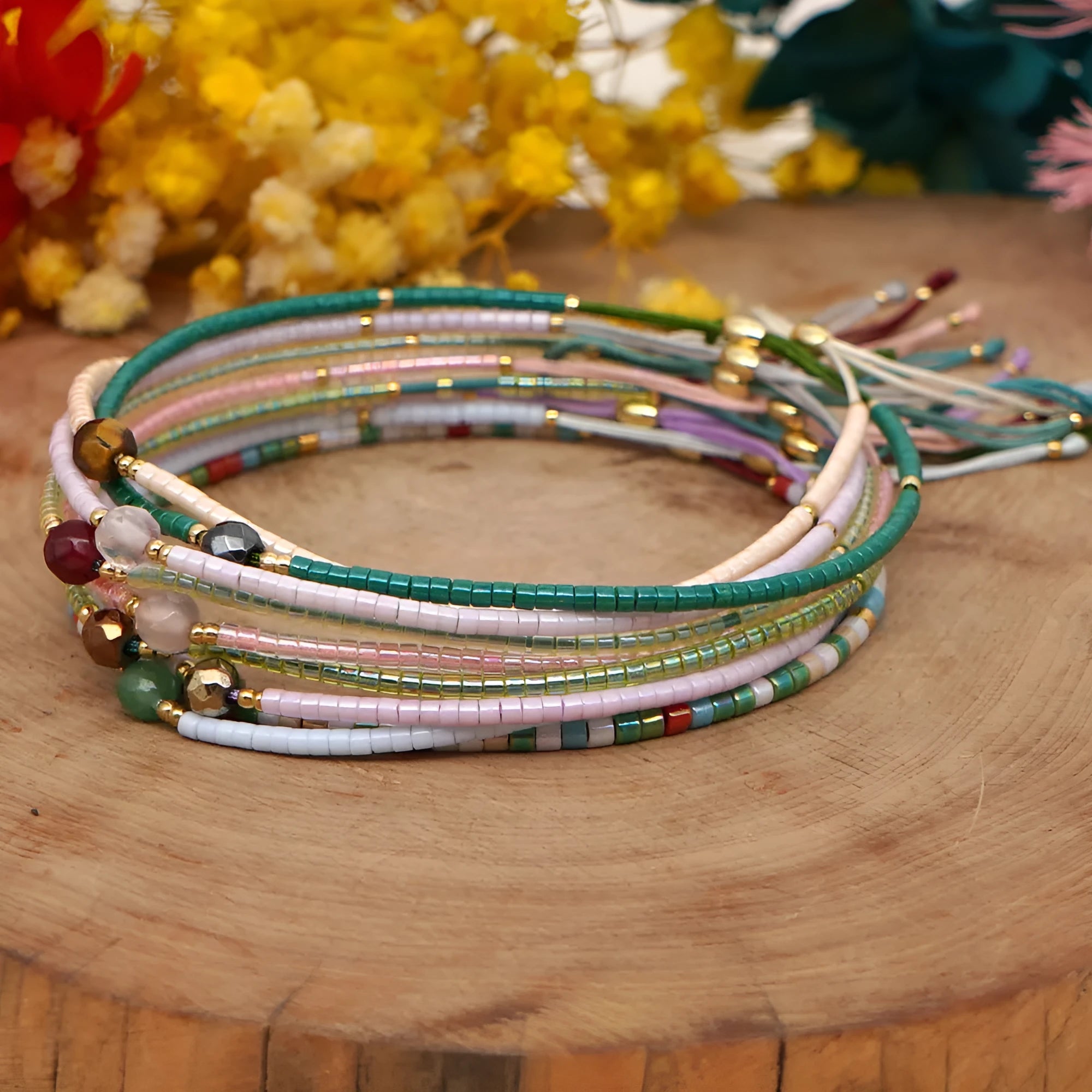 Handmade bohemian style bracelet with geometric semi-precious stone and colourful glass beads on a wrist.