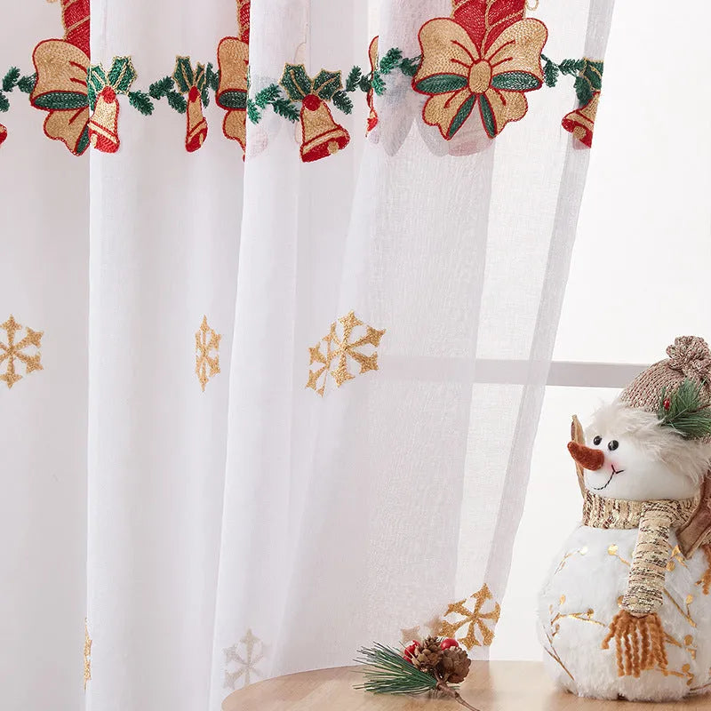Pair of white polyester Christmas curtains with embroidered red snowflake design hung on a window