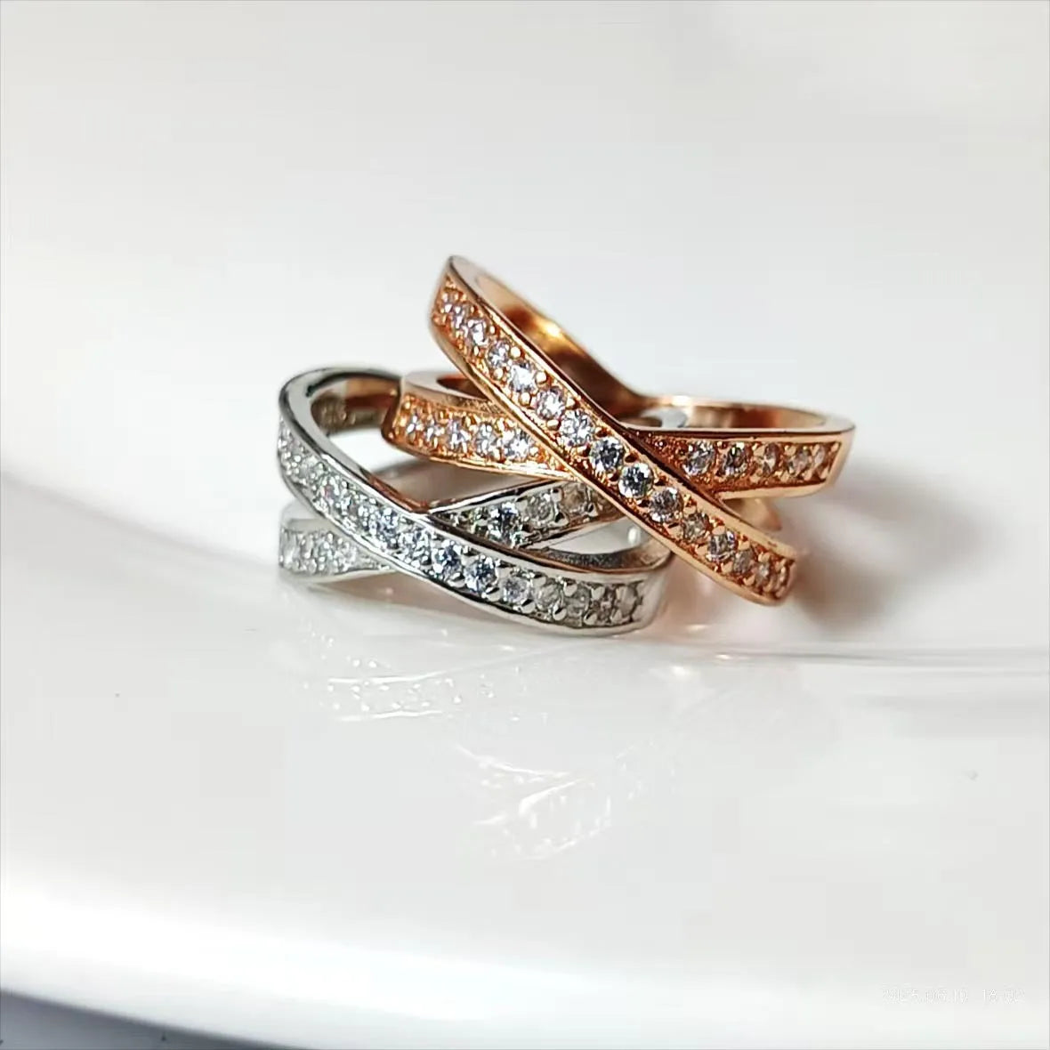 Simple silver cross ring with micro-inlaid zircon detail on a model's finger.