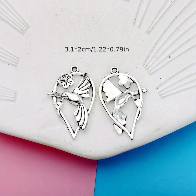 Close-up of a silver-toned alloy magpie bird pendant charm with electroplated finish, shown from the front.