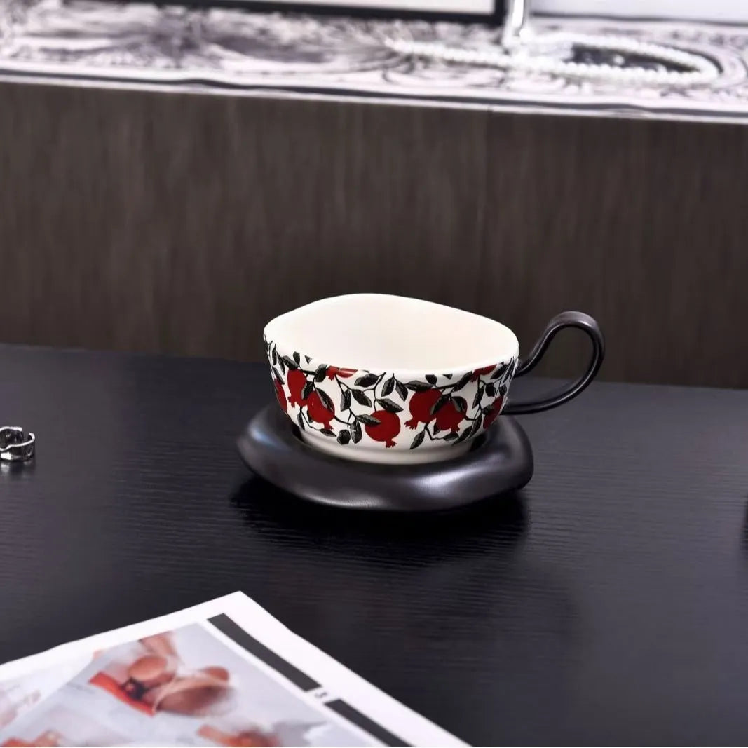 Antique style ceramic coffee cup and saucer set with medieval botanical print in black or orange.