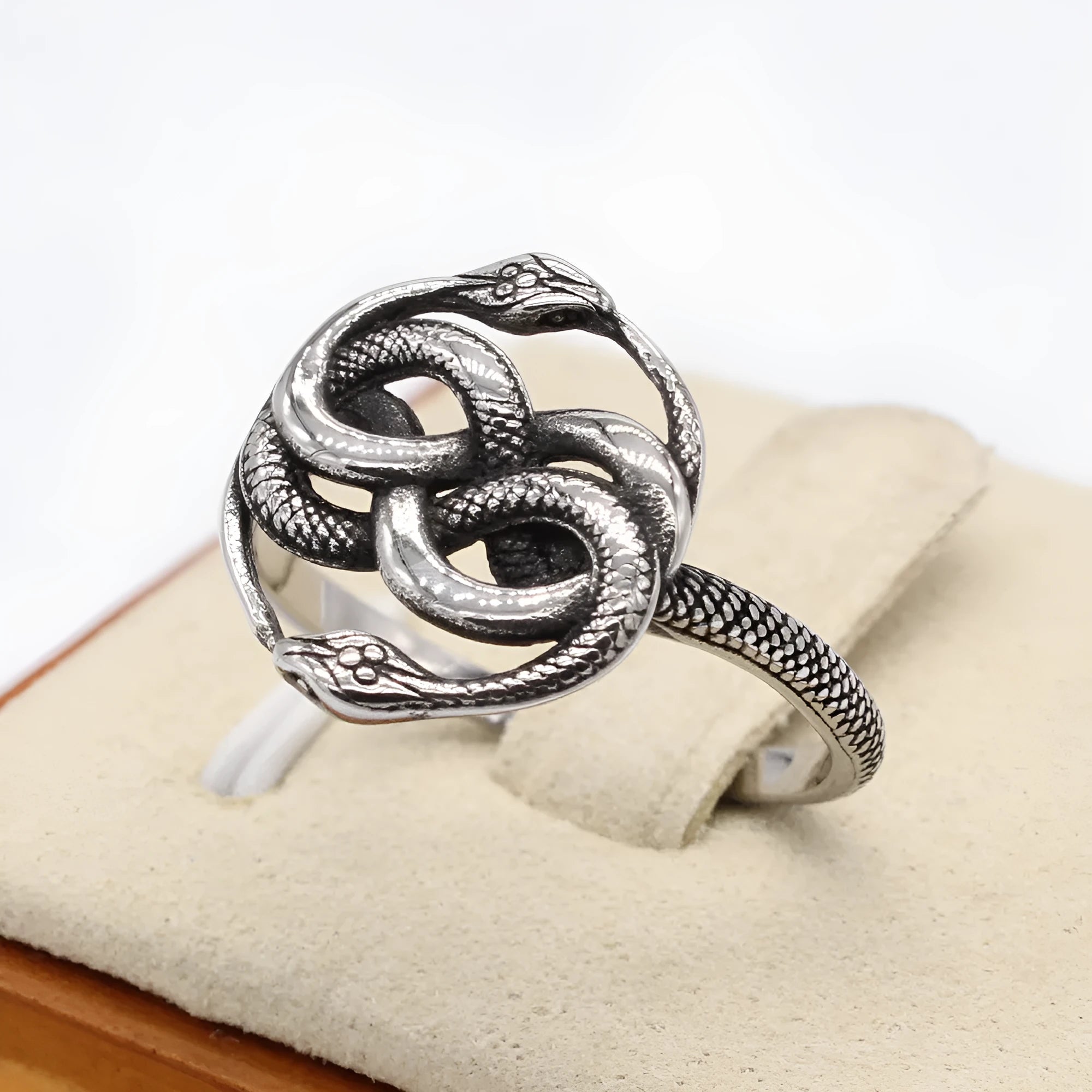 Steel coloured titanium steel ring featuring a detailed retro double snake design on a finger.