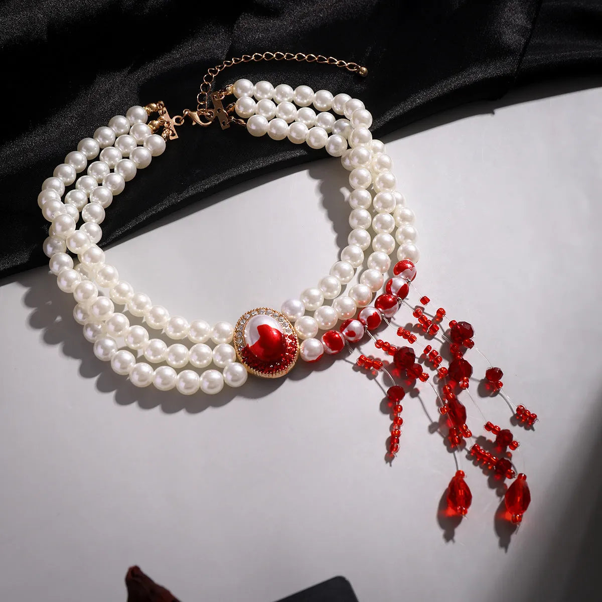 Gothic style gold electroplated pearl collar necklace set with matching bracelet and stud earrings on a dark background.