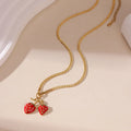 Alloy strawberry fruit pendant necklace on stainless steel chain with red charm and white gradient background.
