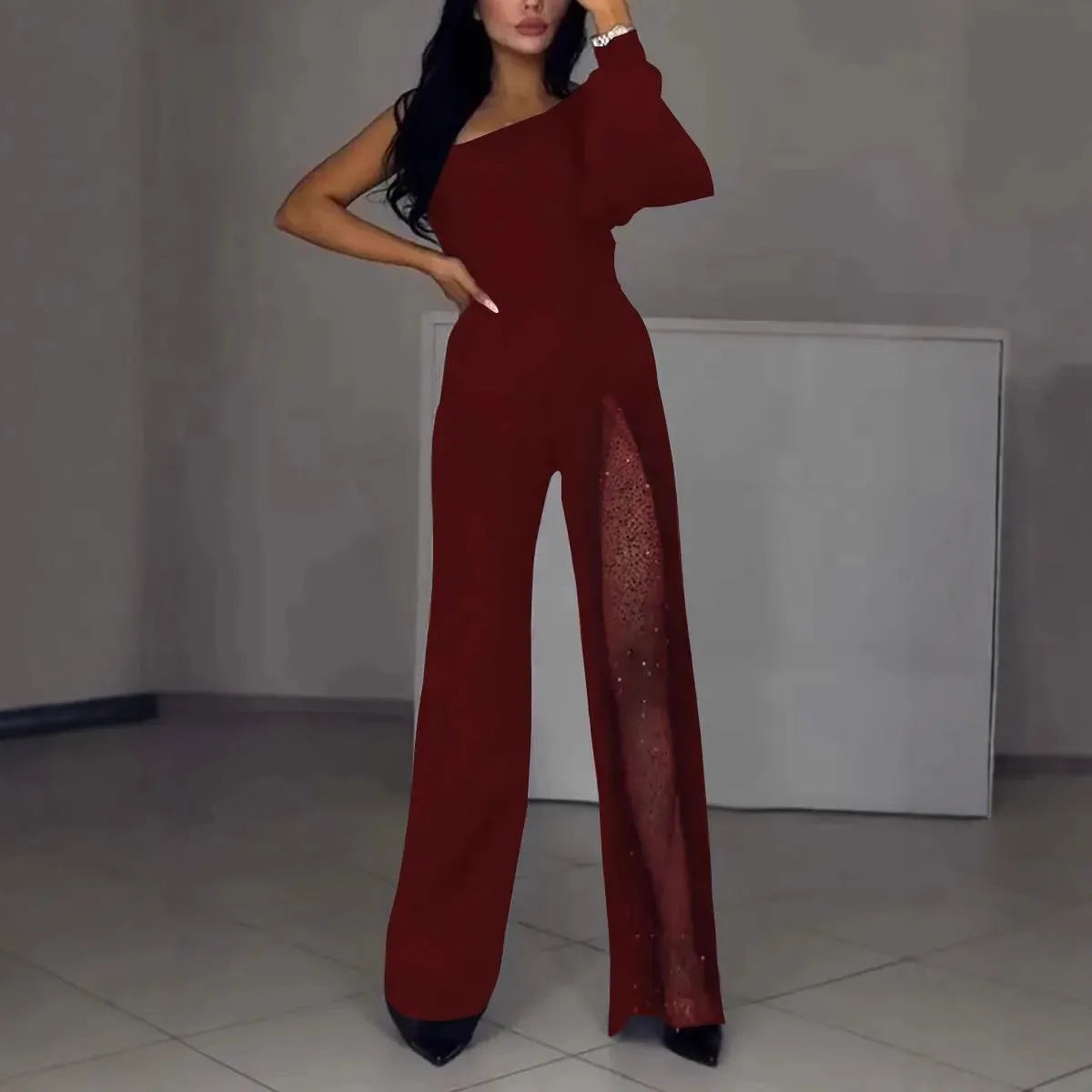Black women's long-sleeve jumpsuit with an oblique shoulder neckline and a high slit on the leg.