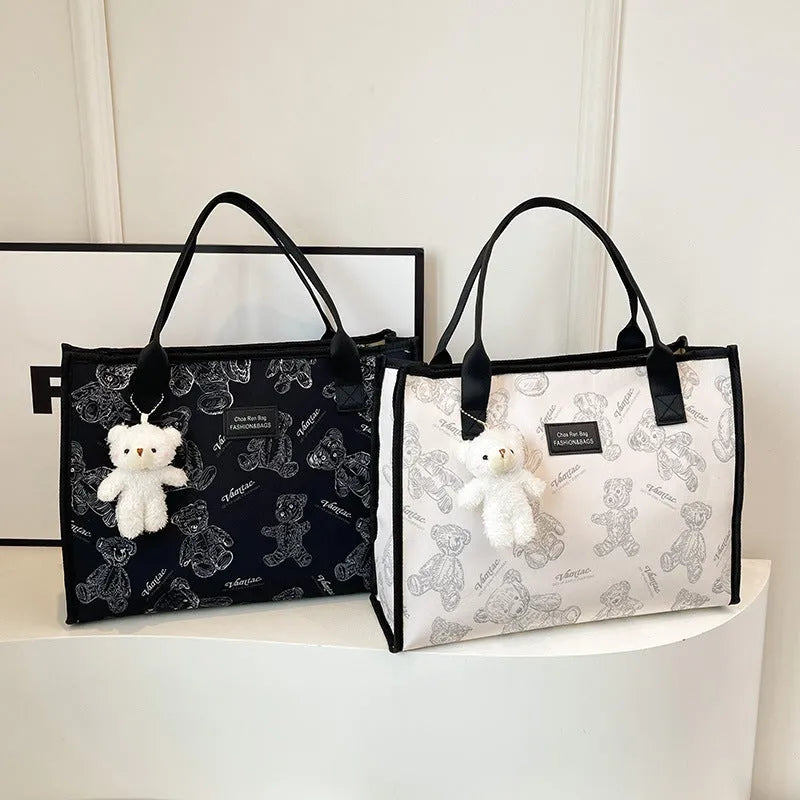 Women's black and white printed canvas tote bag showing rhombus pattern and sandwich pocket.