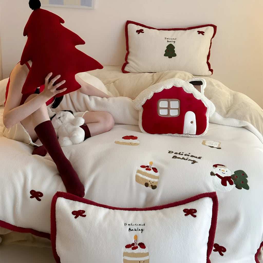 Girl's winter cartoon print bedding four-piece set with bed sheet, duvet cover, and pillowcases on a bed.