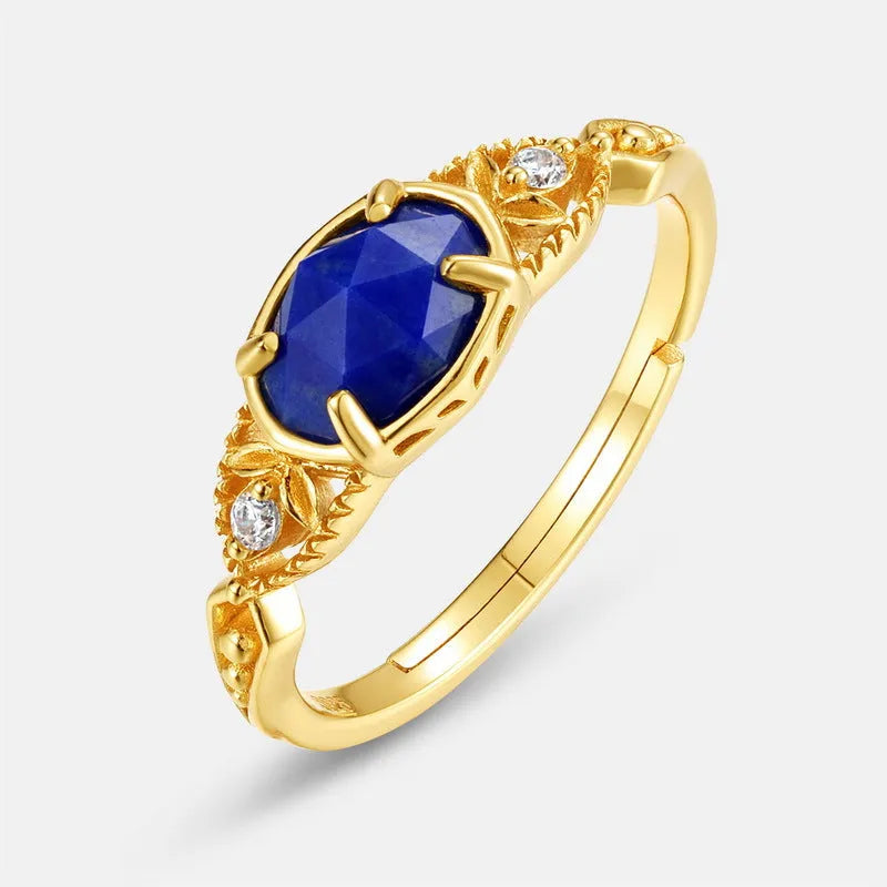 Silver geometric elliptical ring with a blue lapis lazuli stone and round decorative element.