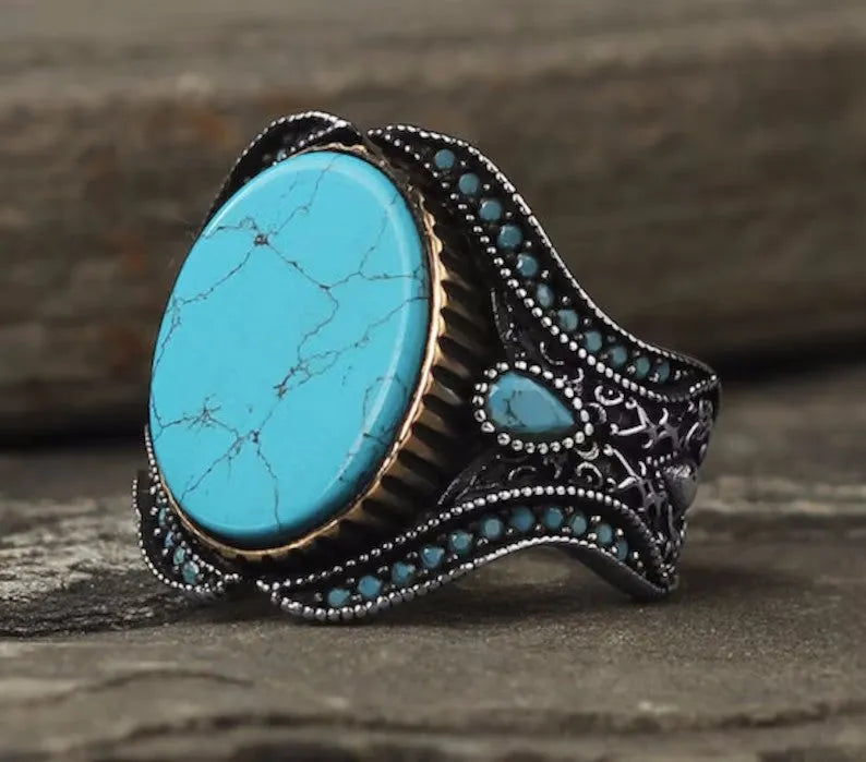 Men's round turquoise alloy ring with antique silver finish shown on finger
