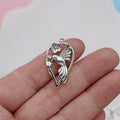 Close-up of a silver-toned alloy magpie bird pendant charm with electroplated finish, shown from the front.