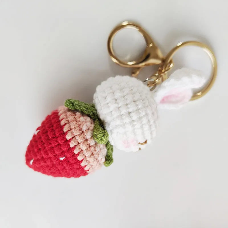 Hand-woven white wire pendant charm with a cartoon rabbit and strawberry design on a key.