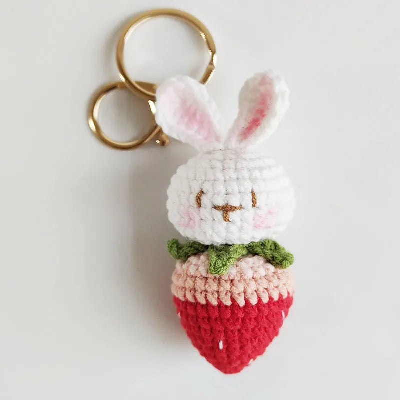 Hand-woven white wire pendant charm with a cartoon rabbit and strawberry design on a key.