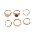 Six light gold irregular alloy rings with geometric shapes on a light background
