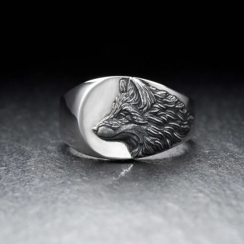 Silver geometric wolf head ring for men on a grey background.