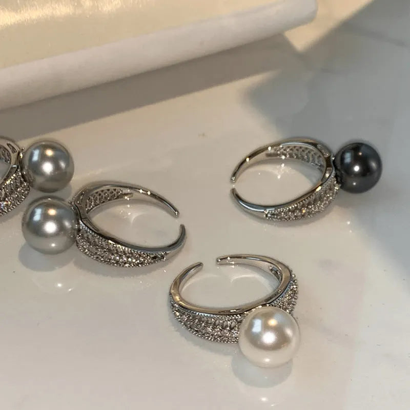 Adjustable open copper ring with geometric shape and black pearl detail on index finger