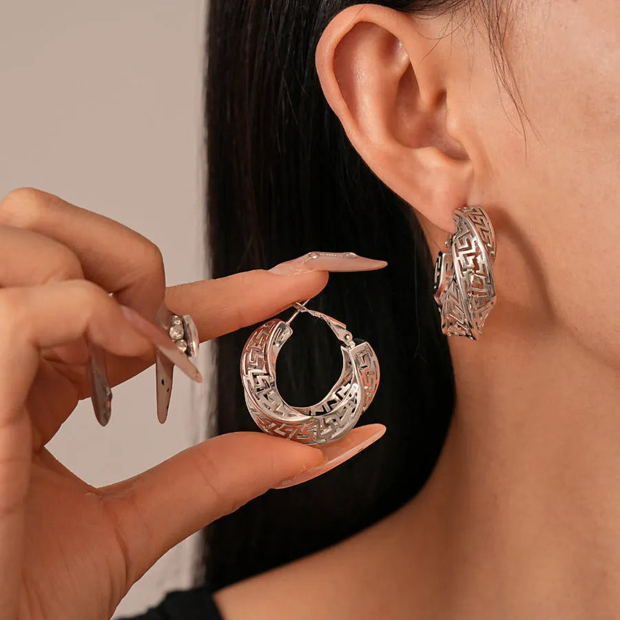 Geometric women's hollow stud earrings in gold or silver with exaggerated twisted round design