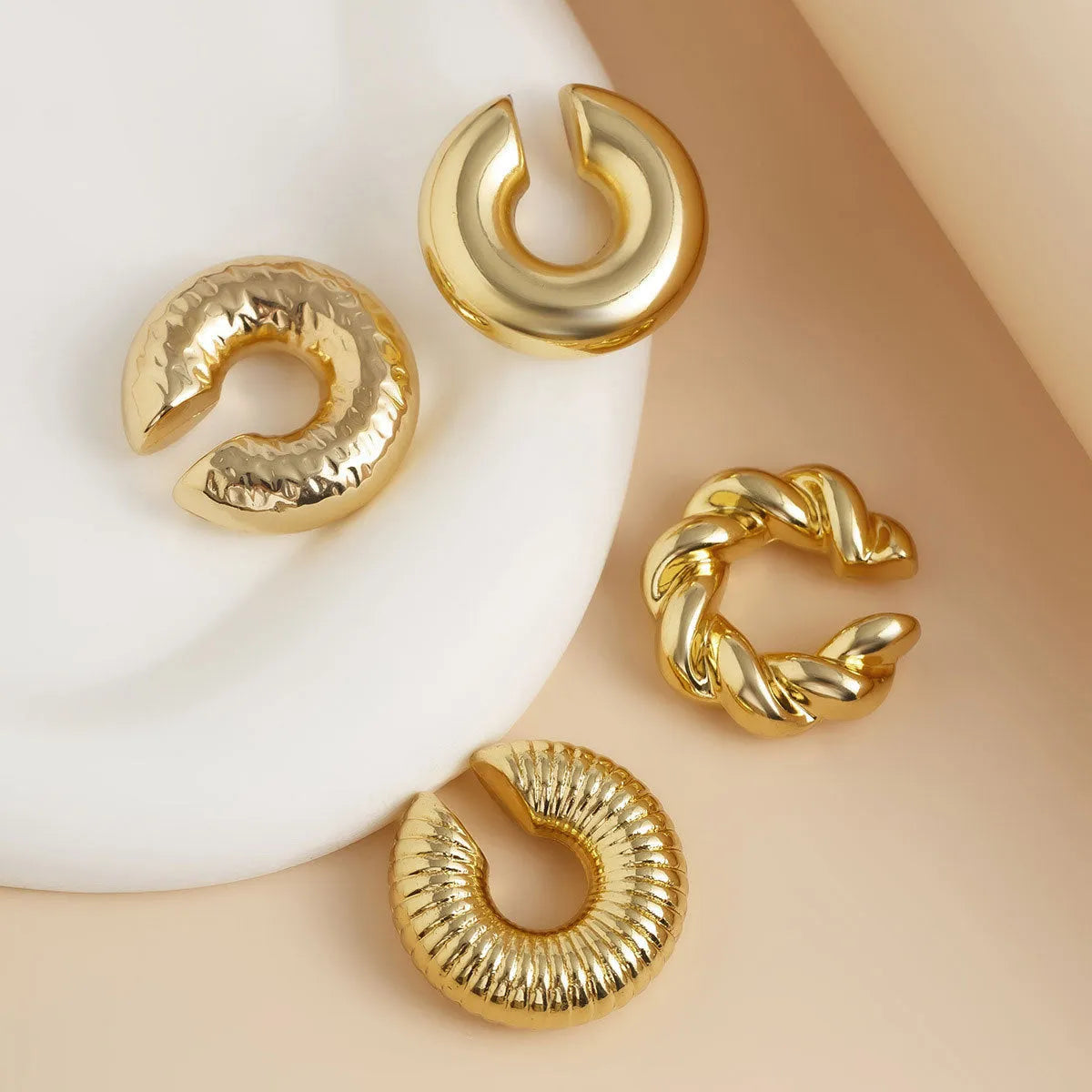 Geometric ear clip set in gold and silver colours for non-pierced wear with exaggerated design