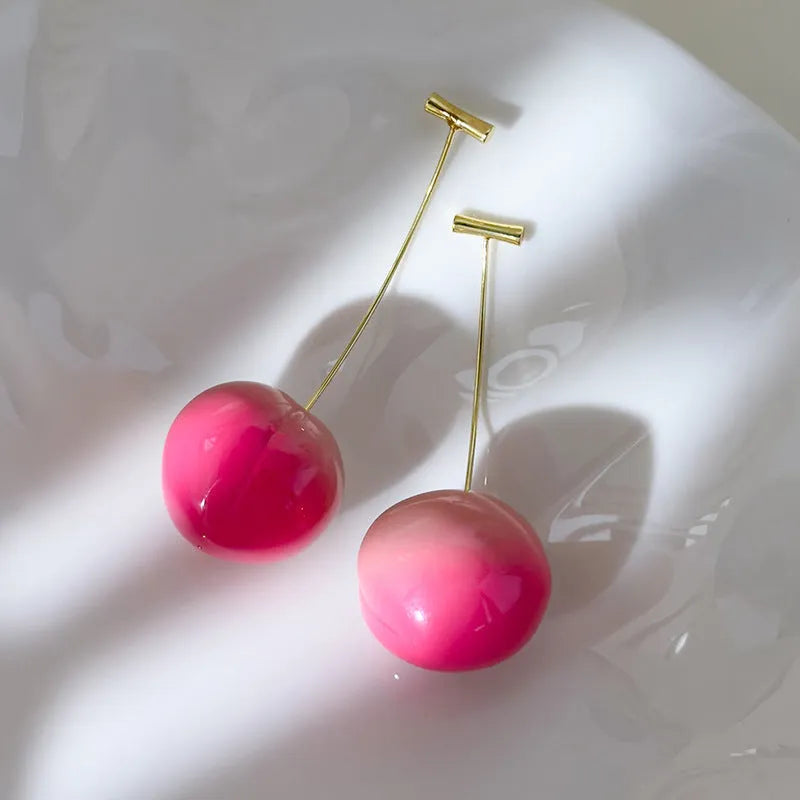 A pair of colourful acrylic peach-shaped stud earrings on a copper post, shown in small and large size options.
