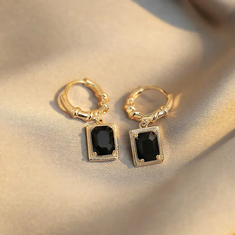 A pair of square geometric copper earrings with a black zircon in a French court retro setting.