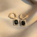 A pair of square geometric copper earrings with a black zircon in a French court retro setting.