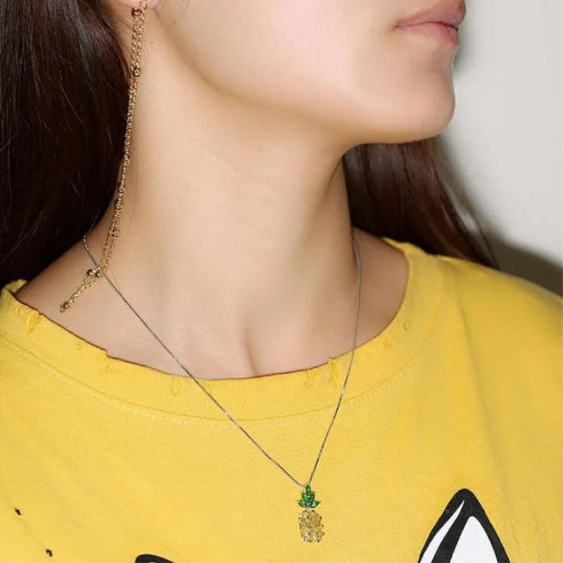 Silver geometric pineapple pendant necklace with diamond details on a model.