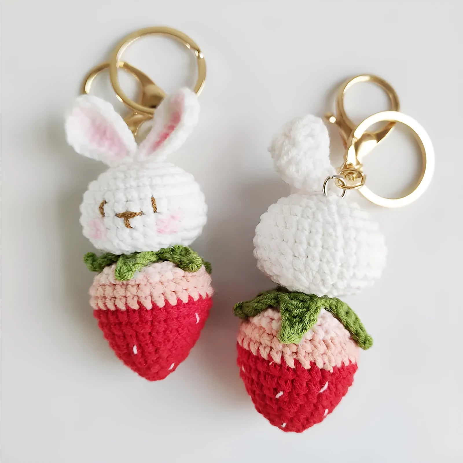 Hand-woven white wire pendant charm with a cartoon rabbit and strawberry design on a key.