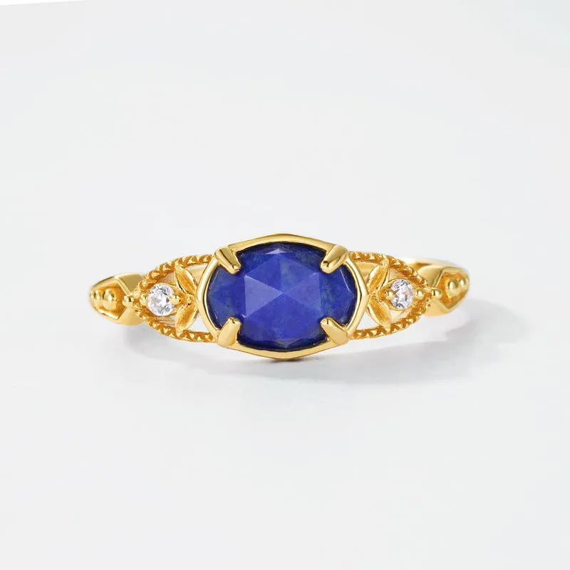 Silver geometric elliptical ring with a blue lapis lazuli stone and round decorative element.