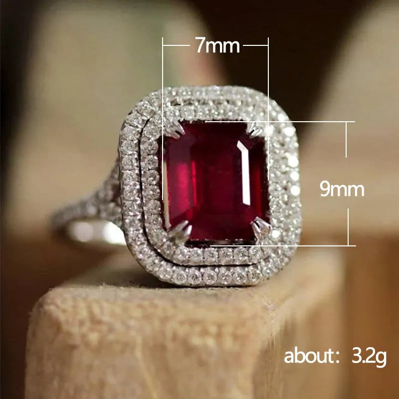 Women's copper square geometric ring with red rhinestones on a finger.