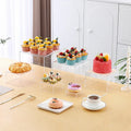White plastic modular cube set assembled as a tiered desktop dessert display stand.