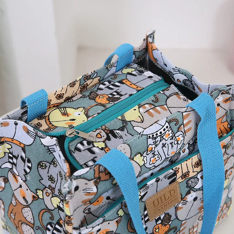 Women's printed canvas tote bag with aluminium hardware in a choice of floral and cat designs.