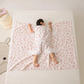 Patterned anti-kick sleeping bag blanket laid flat on a bed, showing its quilted texture.
