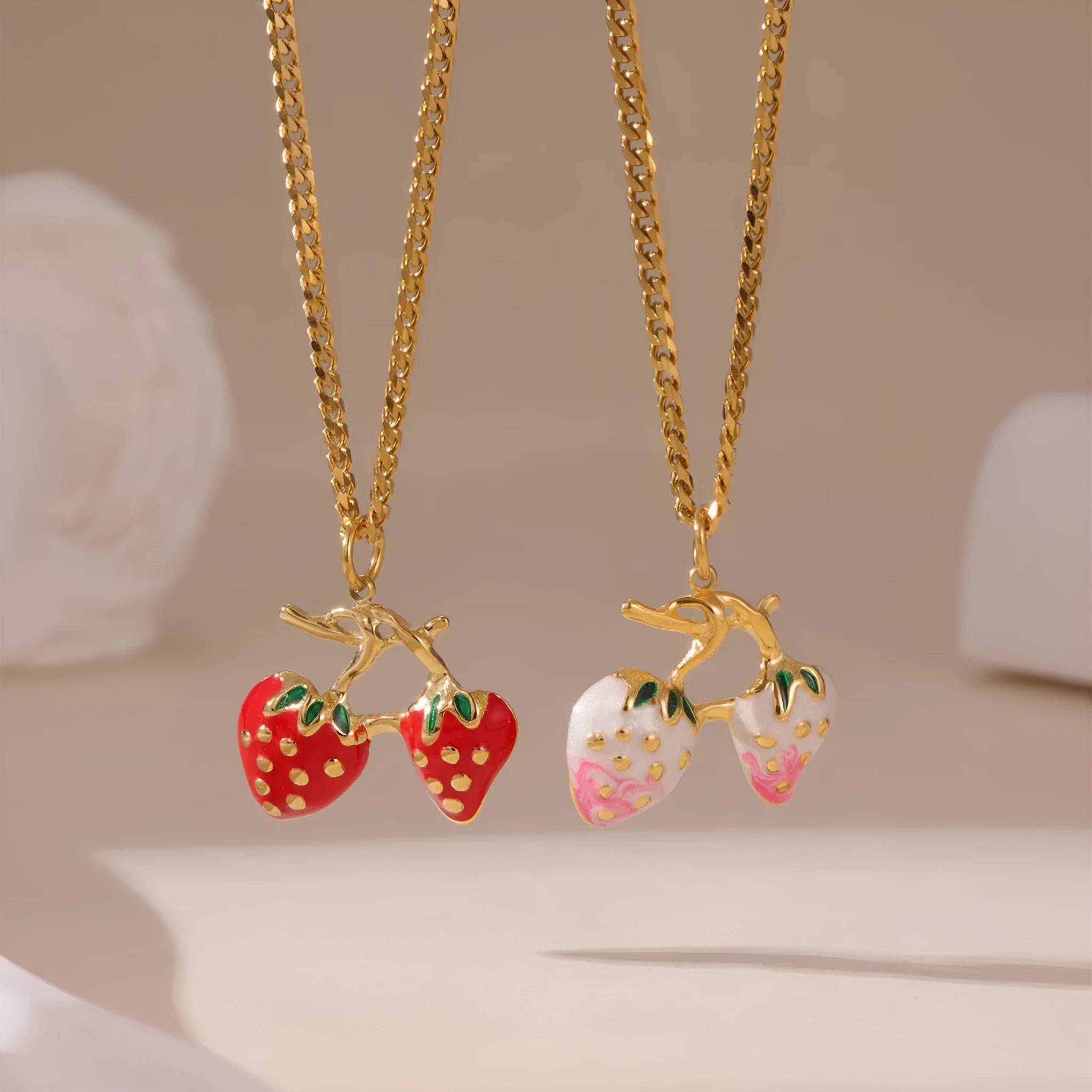 Alloy strawberry fruit pendant necklace on stainless steel chain with red charm and white gradient background.